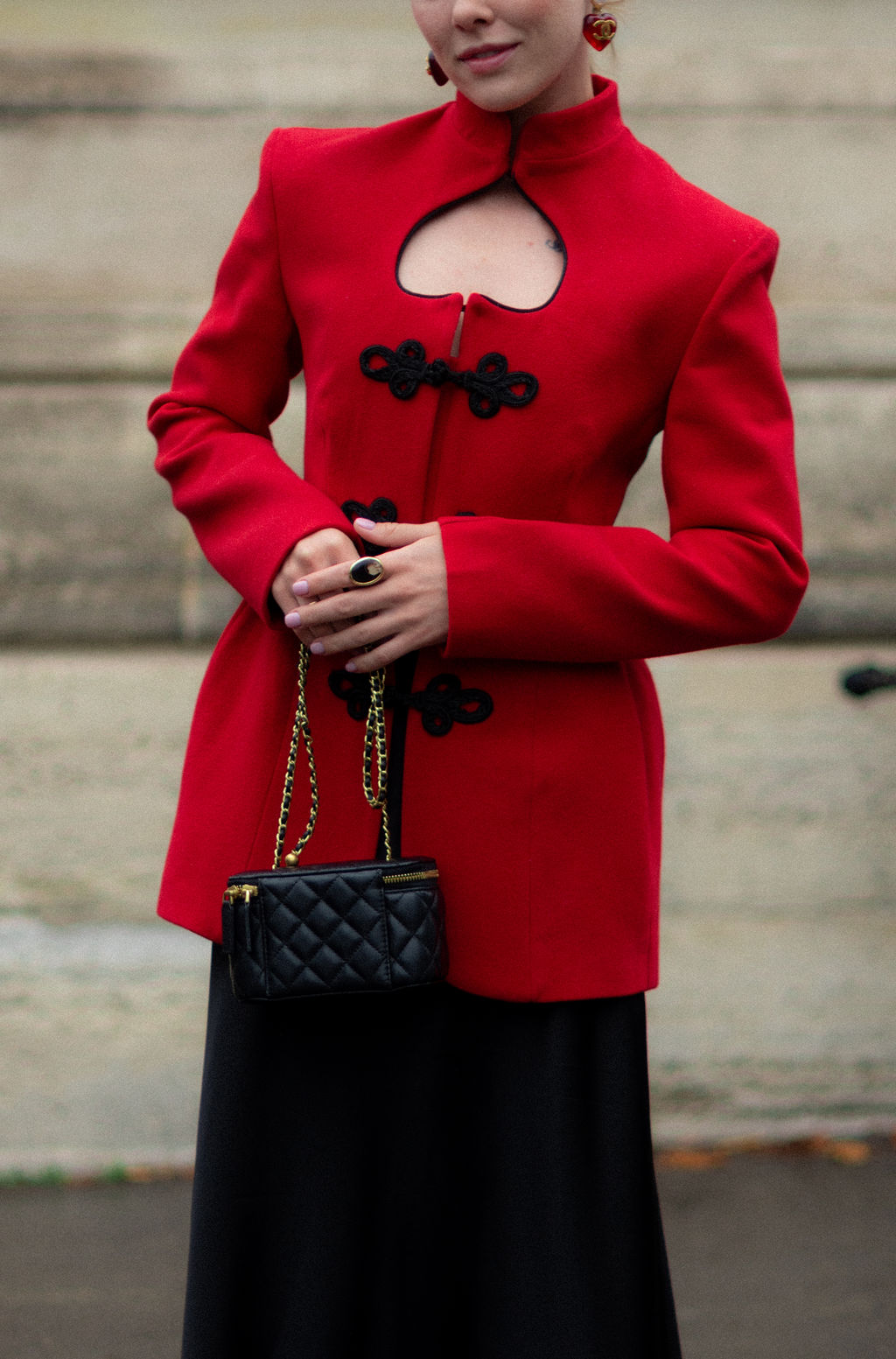 Détail d'une tenue avec une veste rouge vif au défilé Givenchy
