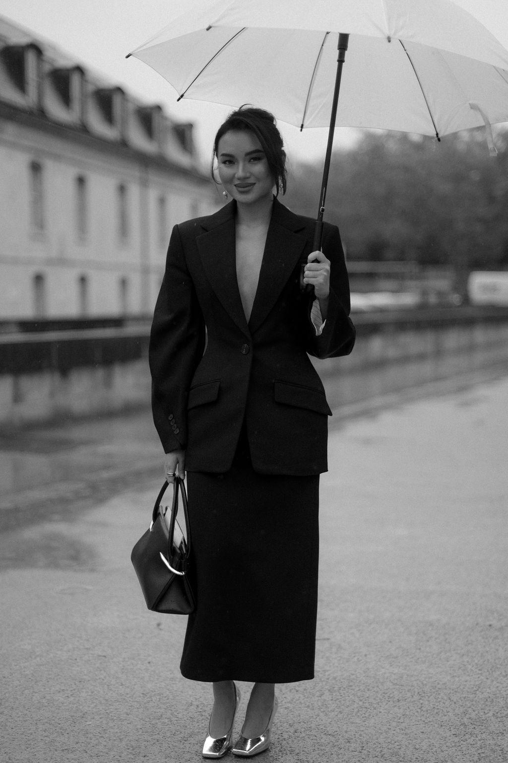 Portrait d'une mannequin en tailleur photographié sous la pluie pendant la Fashion Week de Paris