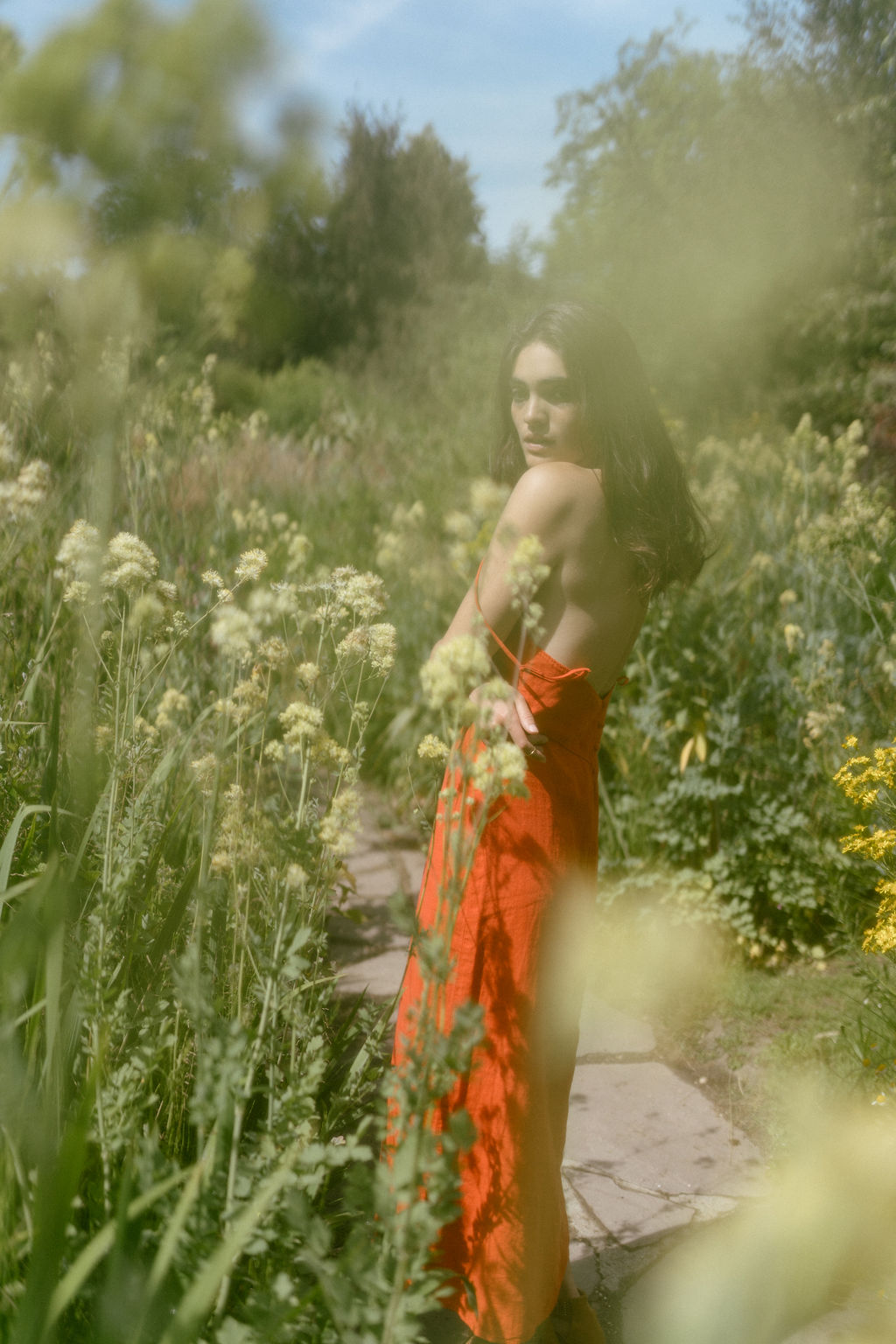 Portrait de Tess Boutmann sous la chaleur d'été dans un jardin fleuri à Paris