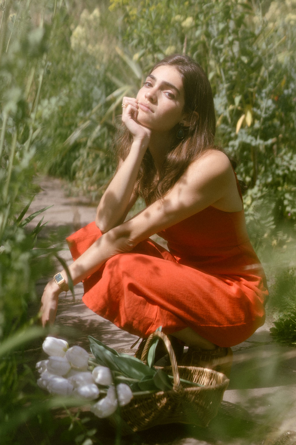 Tess Boutmann pensive au soleil dans un jardin d'été à Paris