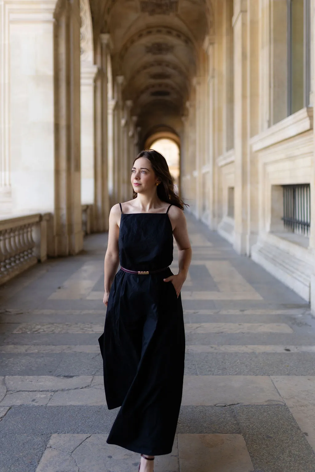 Avocate marchant sous les arcades du Louvre lors d'une séance portrait à Paris