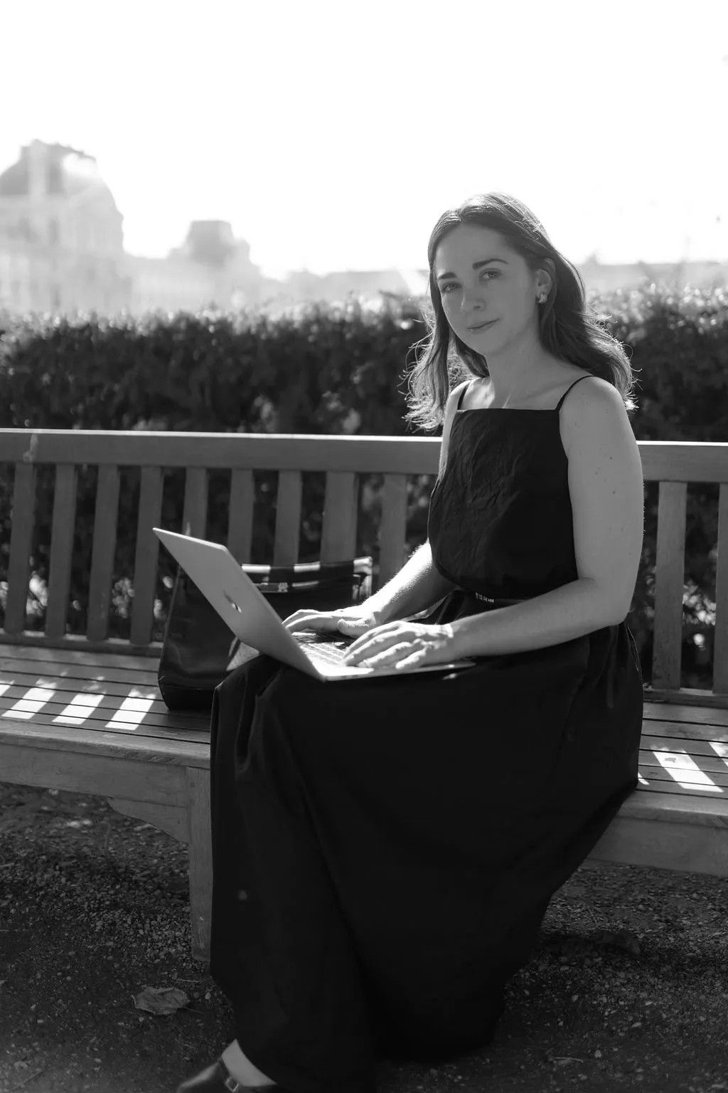 Portrait lifestyle en noir et blanc d'une avocate travaillant sur son ordinateur aux Tuileries