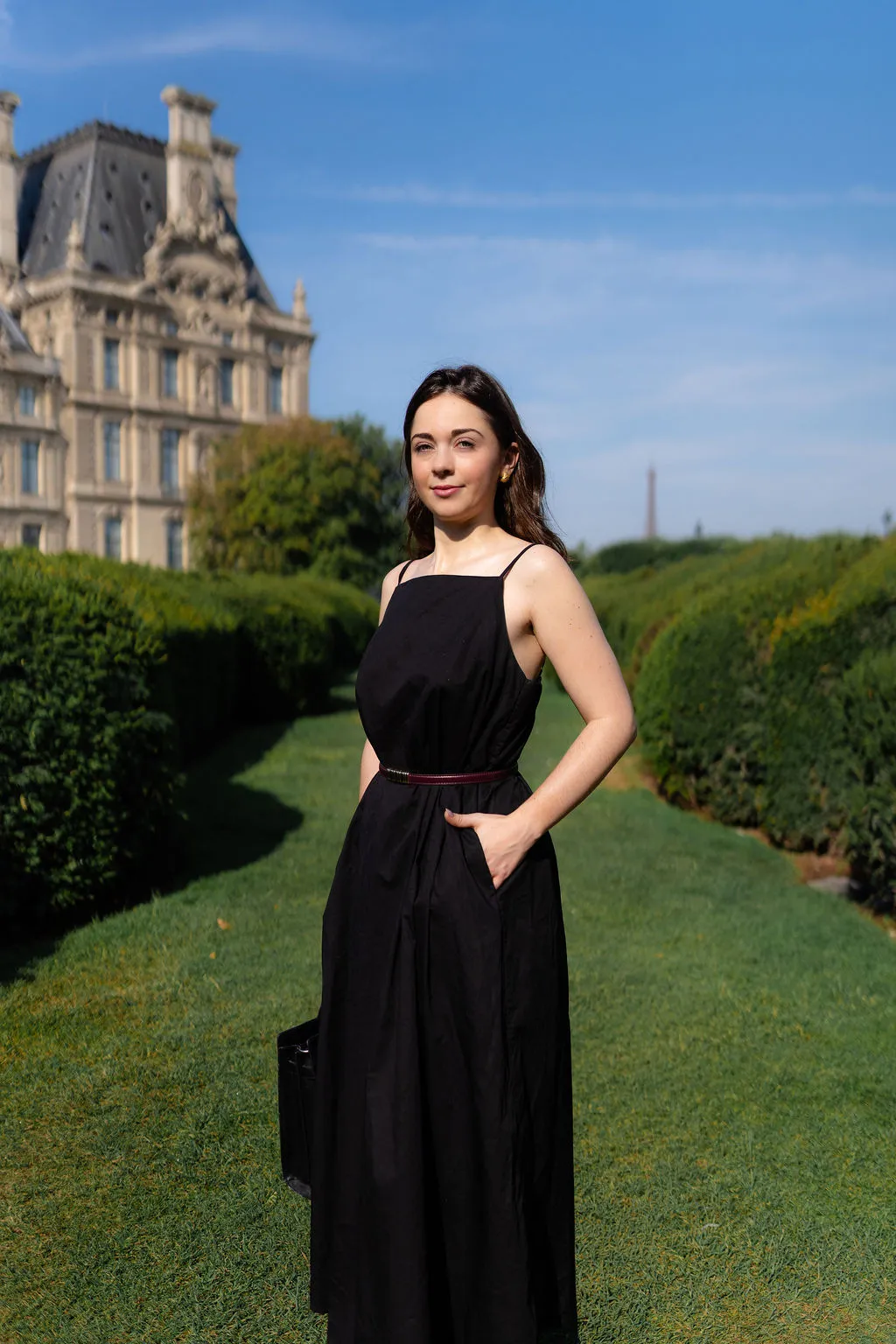 Portrait en pied d'une avocate dans le jardin des Tuileries face au Louvre