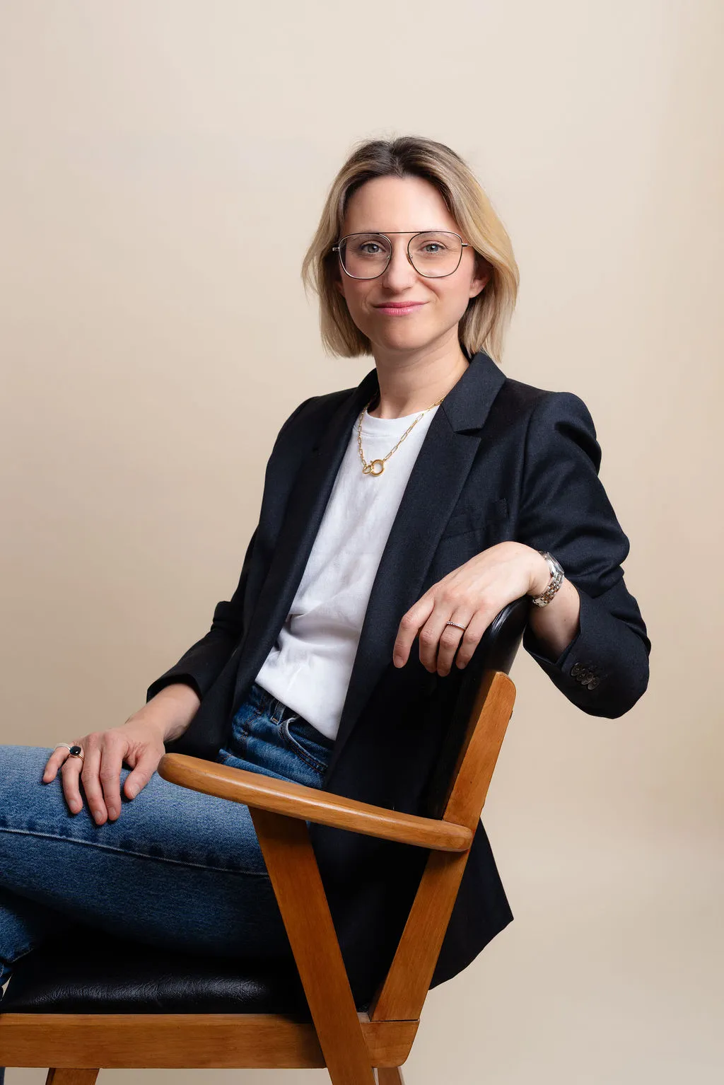 Portrait professionnel souriant en studio, blazer noir et fond neutre, Paris